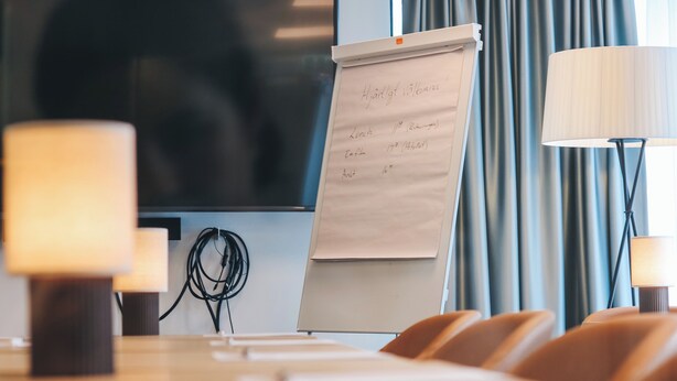 A conference room with a whiteboard, a television, and a table with chairs. - Staffanstorps Gästis Hotell (Staffanstorp)