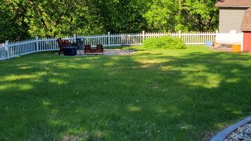 A well-maintained backyard with a white picket fence, a small shed, and a grassy lawn.