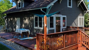 Une maison dotée d’un patio couvert, d’une terrasse en bois et d’un chemin de gravier.