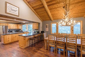 L’intérieur d’une cabine est doté d’un plafond en bois, d’un îlot central avec des tabourets, d’une table à manger avec des chaises et d’un lustre.