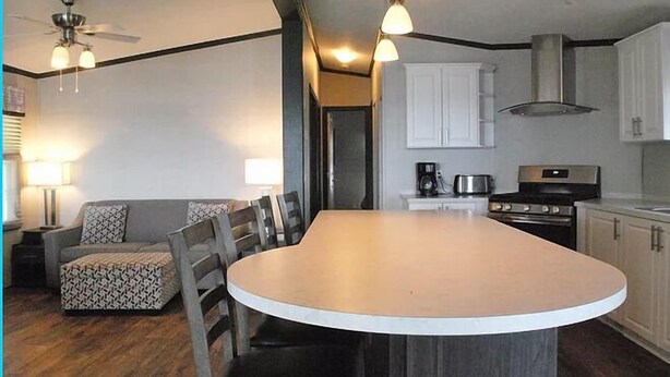 A compact kitchen with a central island, white cabinets, and a ceiling fan. - Great Blue Resorts - Golden Beach Resort (Alnwick/Haldimand)