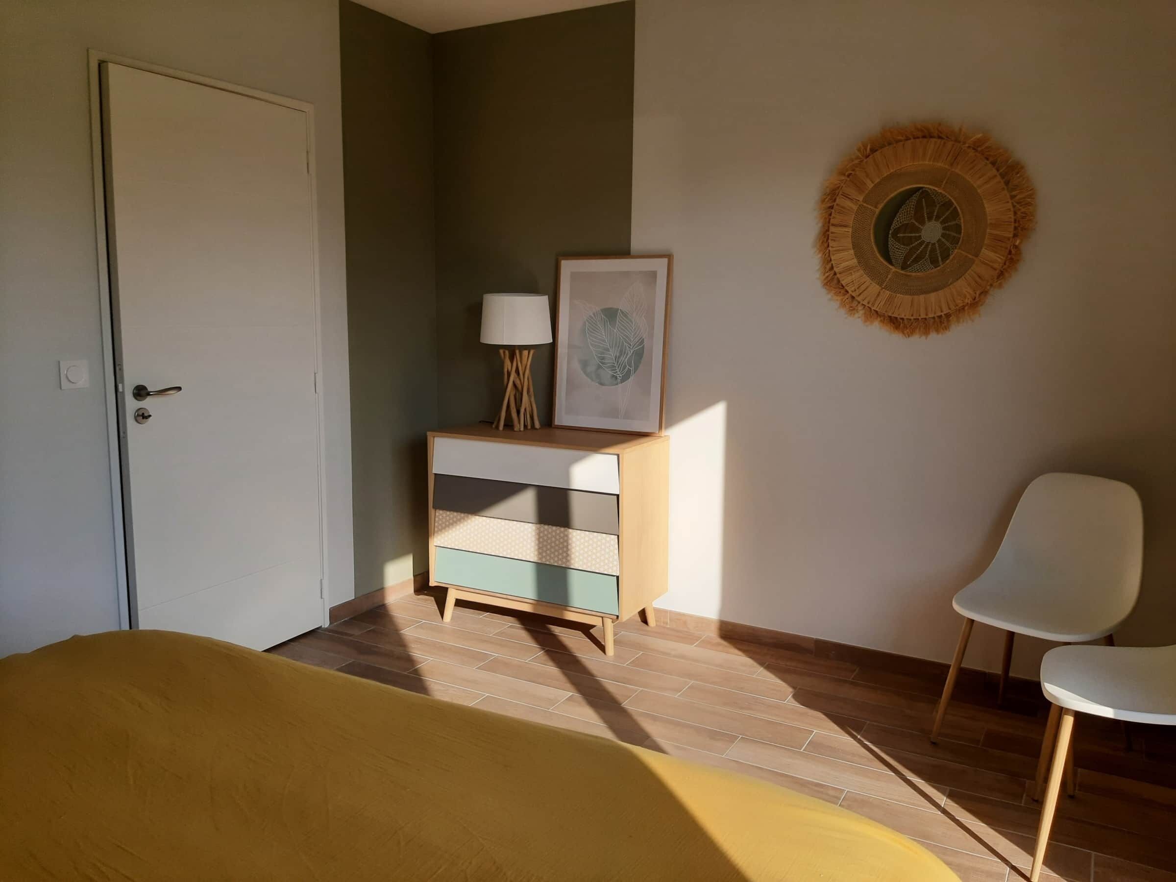 Une chambre comprenant un lit, une table de chevet avec une lampe, un tableau encadré et un objet décoratif fixé au mur.