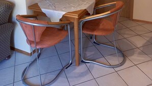 A small dining area with a wooden table and four metal-framed chairs. - Ferienwohnung Tremmbach (Lemberg/Salzwoog)
