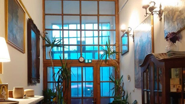 A cozy room with a piano, a wooden cabinet, and a large window with a view. - Boarding house for students and young professionals (București)