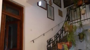 A staircase with a metal railing, a wooden door, and a wall with framed pictures. - Boarding house for students and young professionals (București)