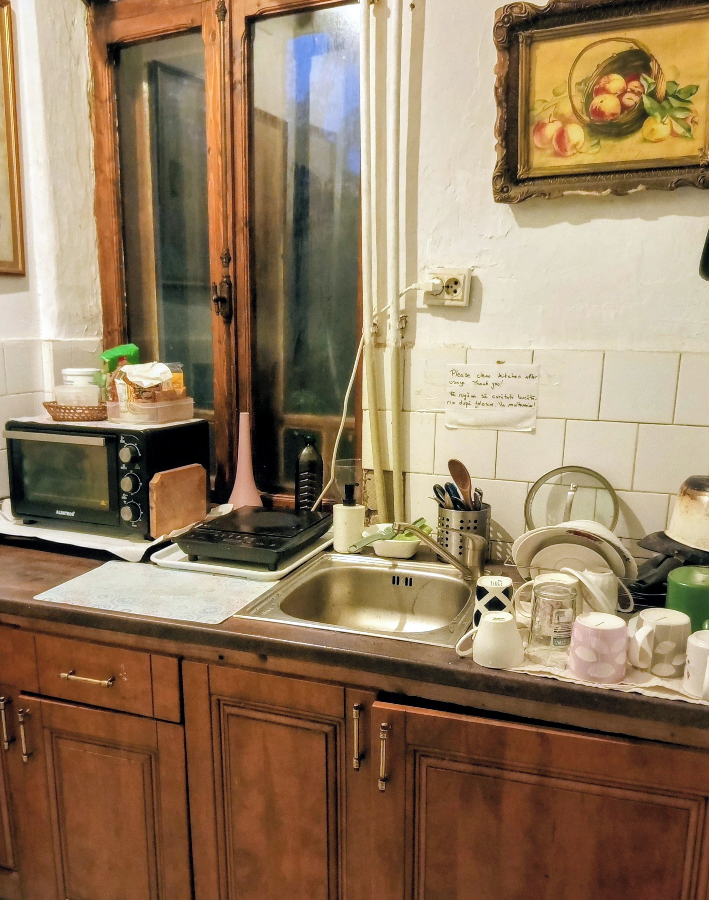 Cozinha equipada com micro-ondas, pia e utensílios domésticos.