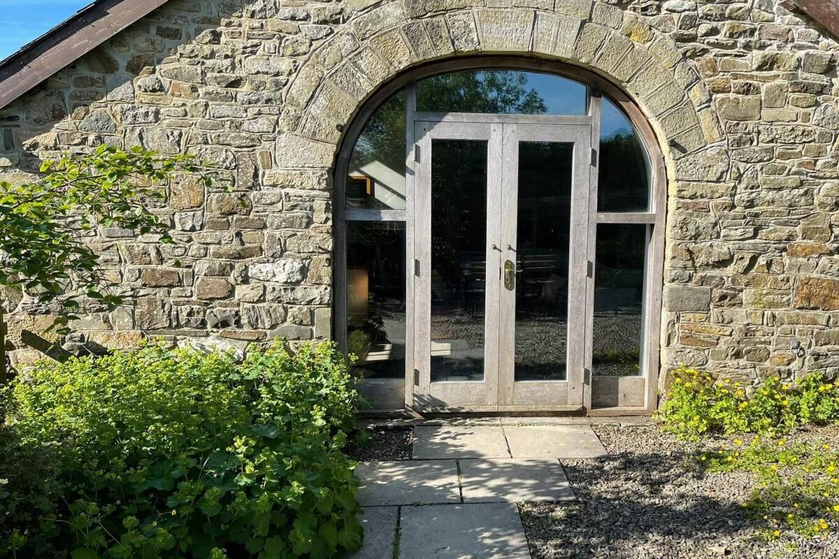 A stone building with a large arched entrance and a glass door.