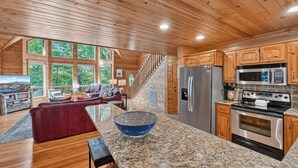 A spacious kitchen with granite countertops, stainless steel appliances, and wooden cabinetry. - Tumnus Ridge - Super Dog Friendly | Hot tub | Fire Pit (Morganton)