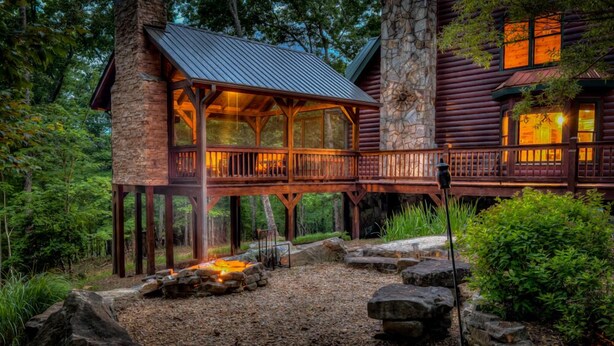 A log cabin with a wooden deck and a stone fireplace. - Tumnus Ridge - Super Dog Friendly | Hot tub | Fire Pit (Morganton)