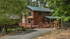 A two-story log cabin with a porch and a wooden deck. - Tumnus Ridge - Super Dog Friendly | Hot tub | Fire Pit (Morganton)