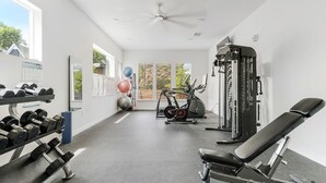 A gym with exercise equipment, a dumbbell rack, and a bench. - Downtown Modern Bungalow (Dallas)