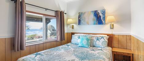 A bedroom with a bed, curtains, a window with a view, a painting, and a nightstand.