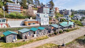 A residential area with multi-story houses, a small building with a sign, and a row of houses with green roofs.