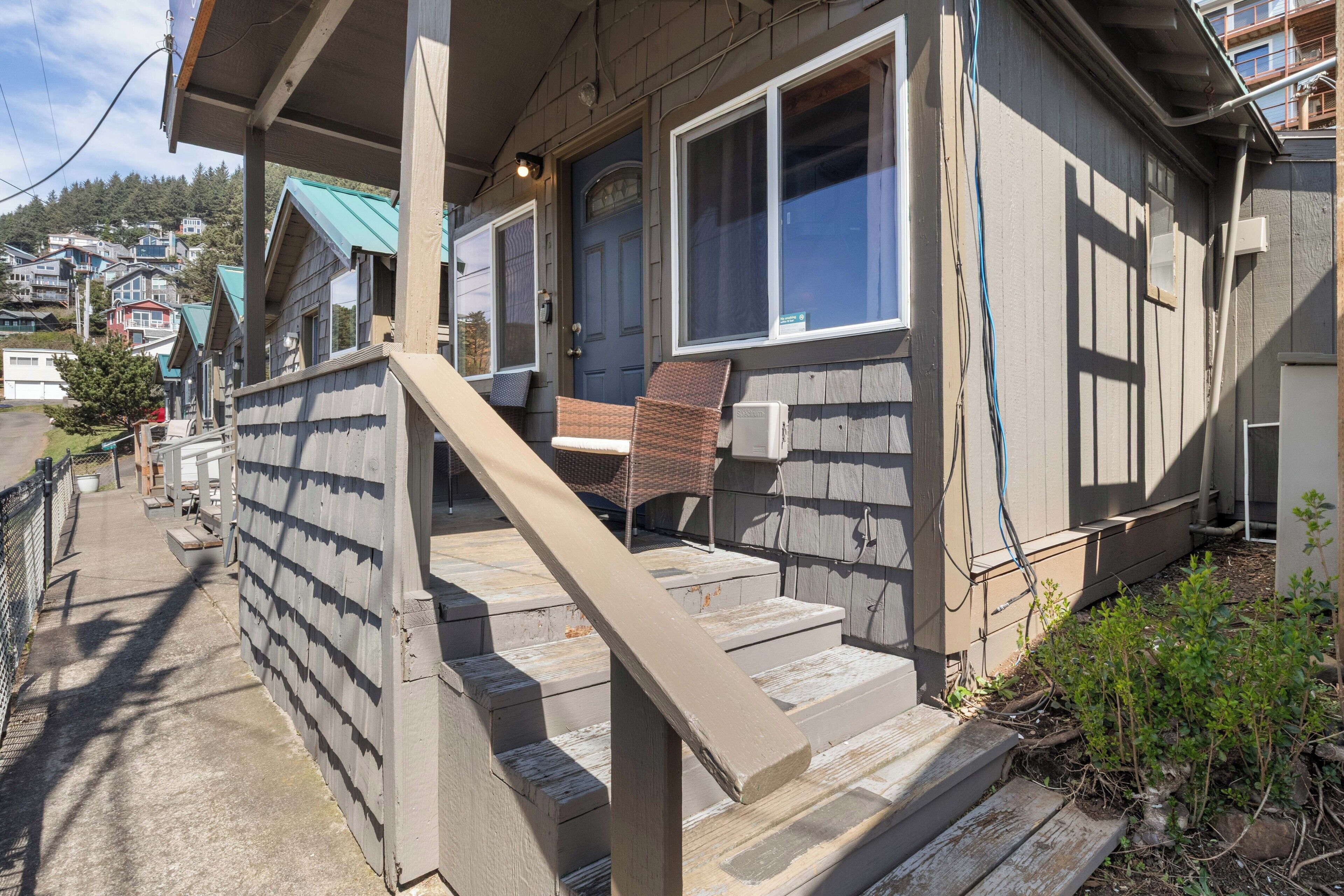 A residential building with a porch, steps, and a window.