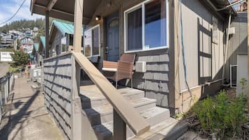 A residential building with a porch, steps, and a window.