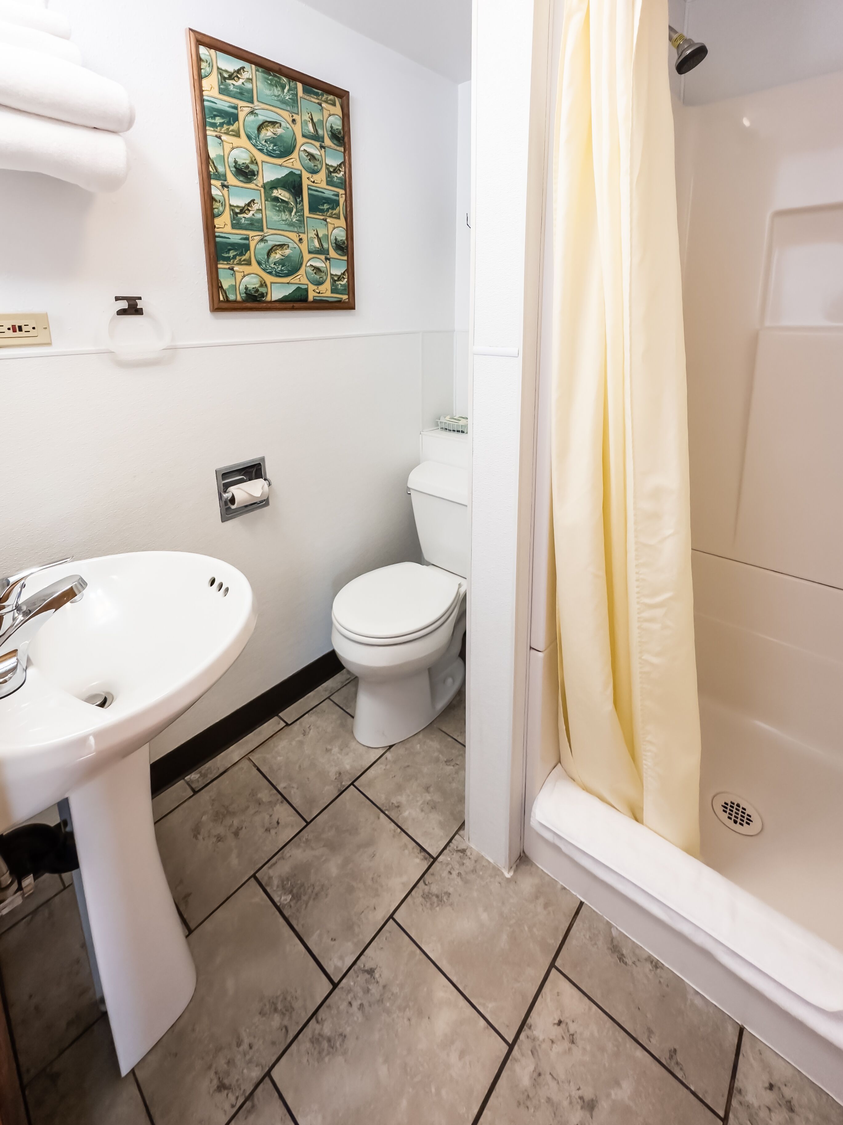 A bathroom with a white sink, toilet, and shower curtain.