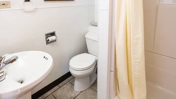 A bathroom with a white sink, toilet, and shower curtain.