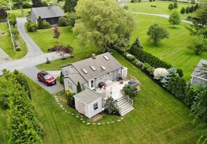 Une vue aérienne d’une maison avec une grande pelouse, une allée et un garage.
