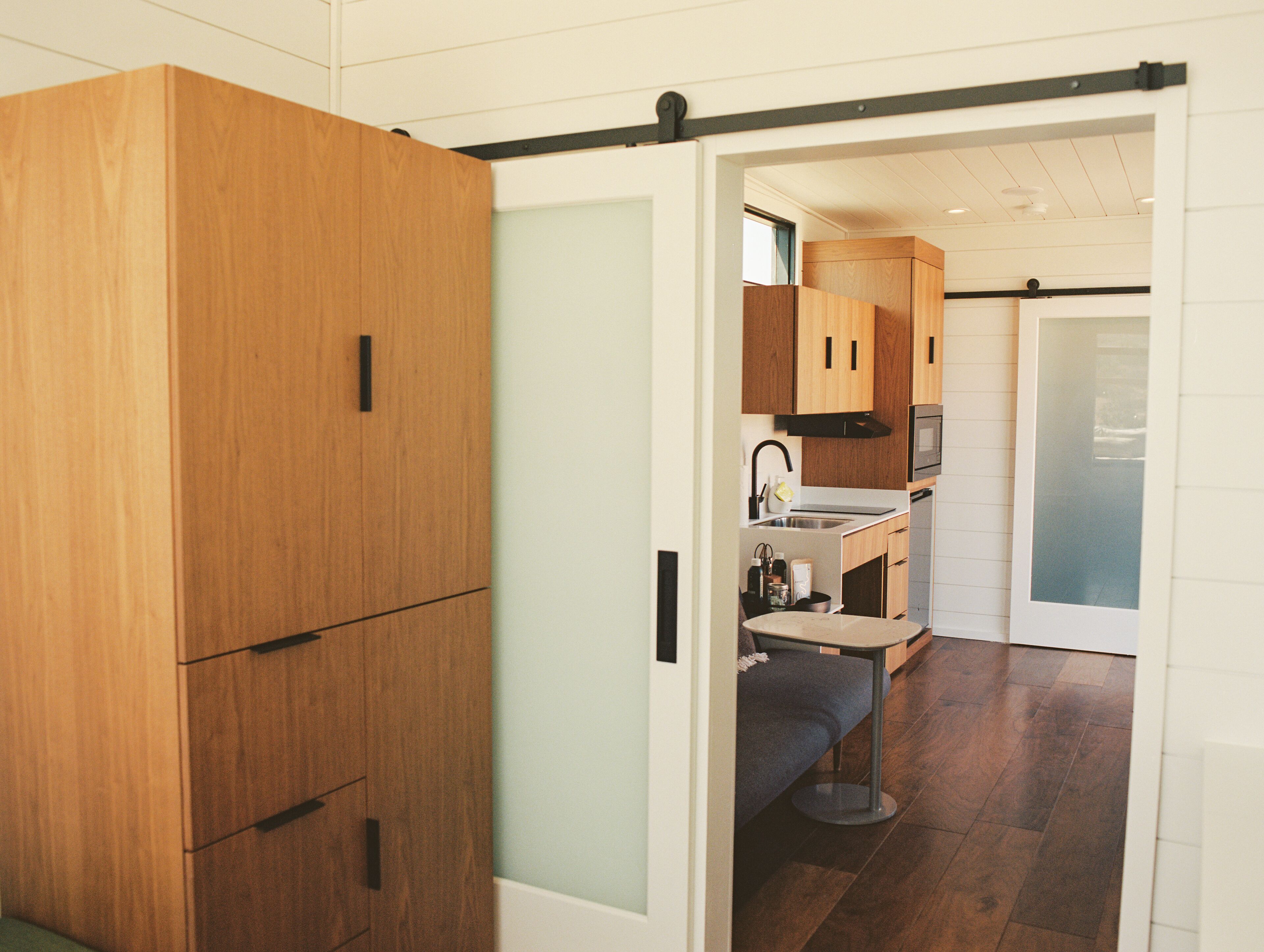 A compact kitchen with wooden cabinets, a sink, and a microwave.