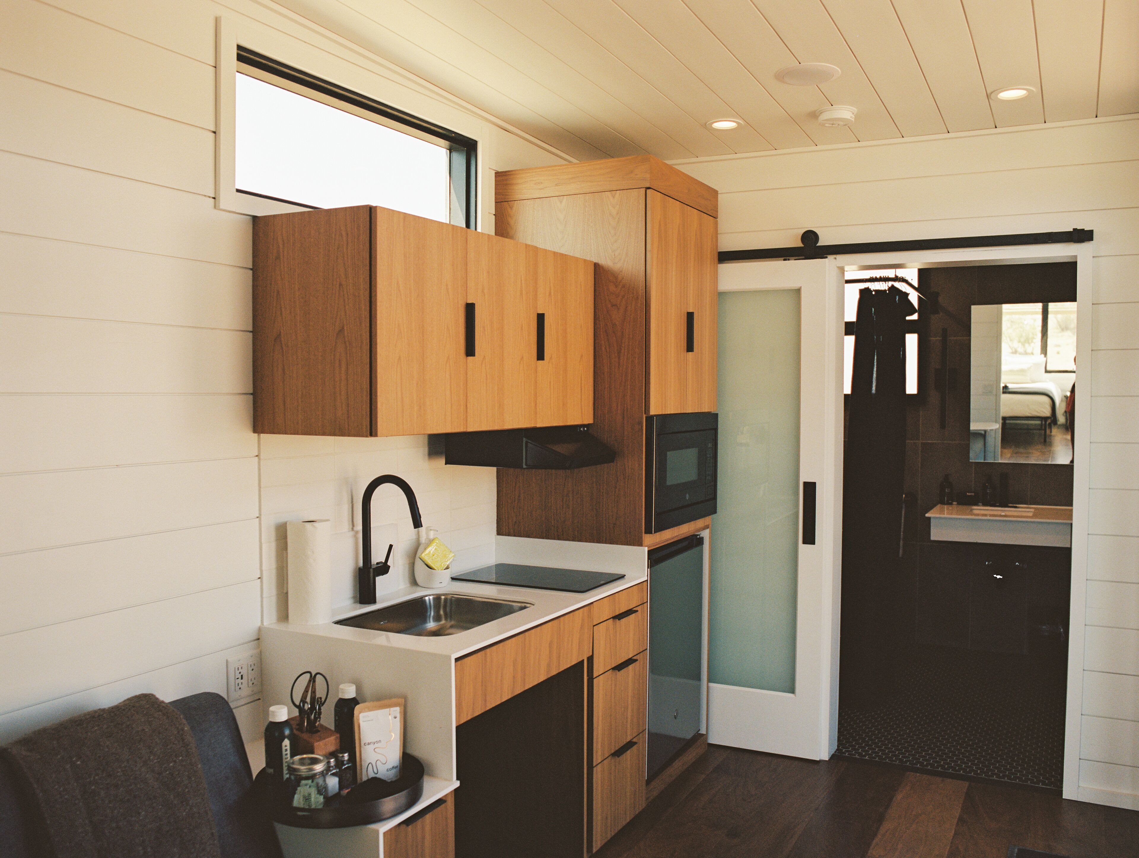 A compact kitchen with wooden cabinets, a sink, and a microwave.