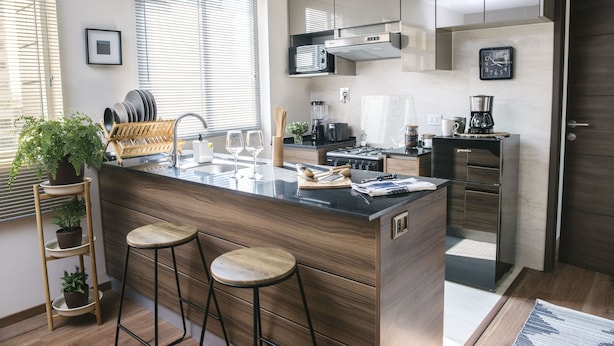 A modern kitchen with a central island, stainless steel appliances, and wooden cabinetry.