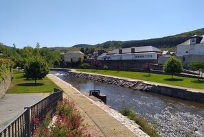 A riverside walkway with stone paving, a metal railing, and a row of trees. - Joaquin's work, your refuge in El Bierzo. <br> (Folgoso de la Ribera)