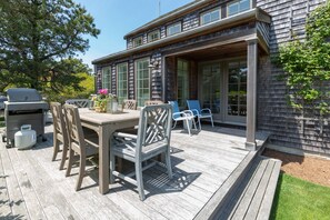 A wooden deck with outdoor furniture, a grill, and a gas tank. - Pond View Cottage- Luxury home near Miacomet beach (Nantucket)