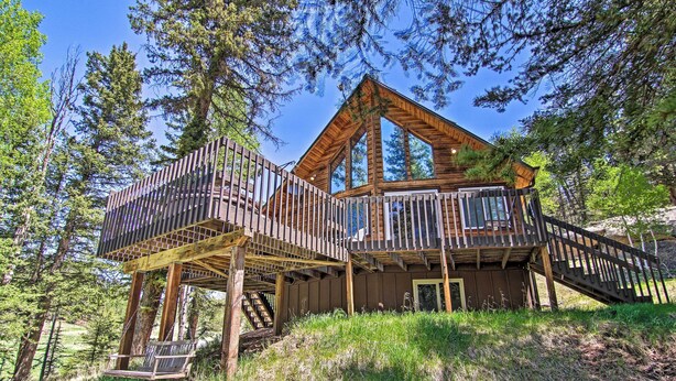 A wooden cabin with a deck and staircase, surrounded by trees. - Florissant Hilltop Hideaway w/ Porch, Pond View (Florissant)