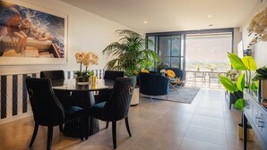 Un comedor moderno con una mesa redonda, sillas tapizadas en negro y una planta grande en maceta.