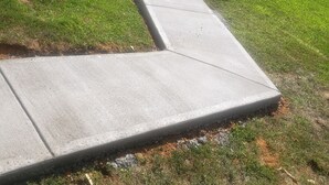 A concrete ramp leading to a wooden deck.