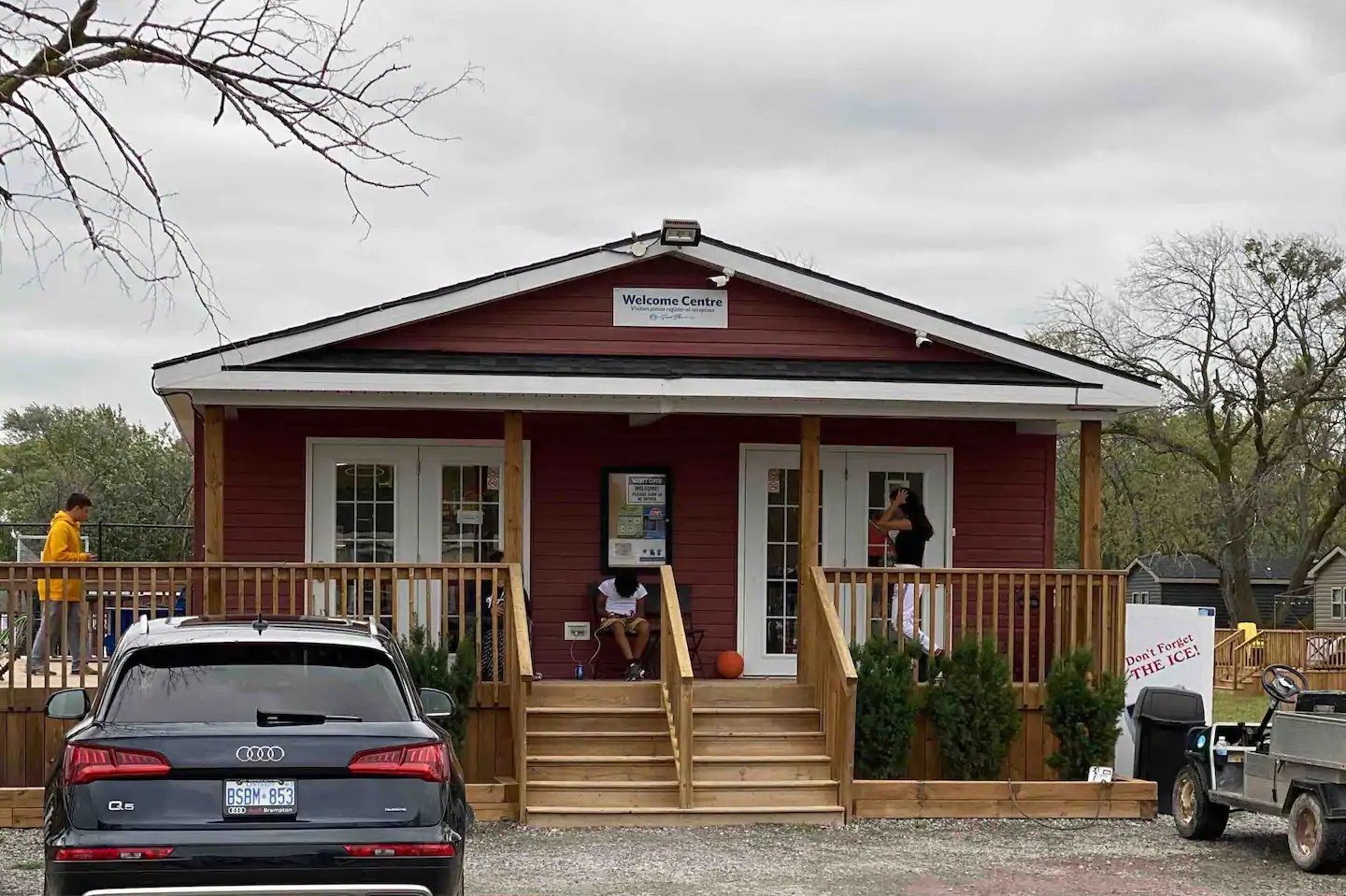 A red building with a sign reading "Welcome Centre" and a wooden staircase leading to the entrance.