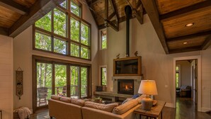 A spacious living room with a large sectional sofa, a fireplace, and a television. - Timber Forge Lodge - Eagles Nest home with views, hot tub, game table, more! (Banner Elk)