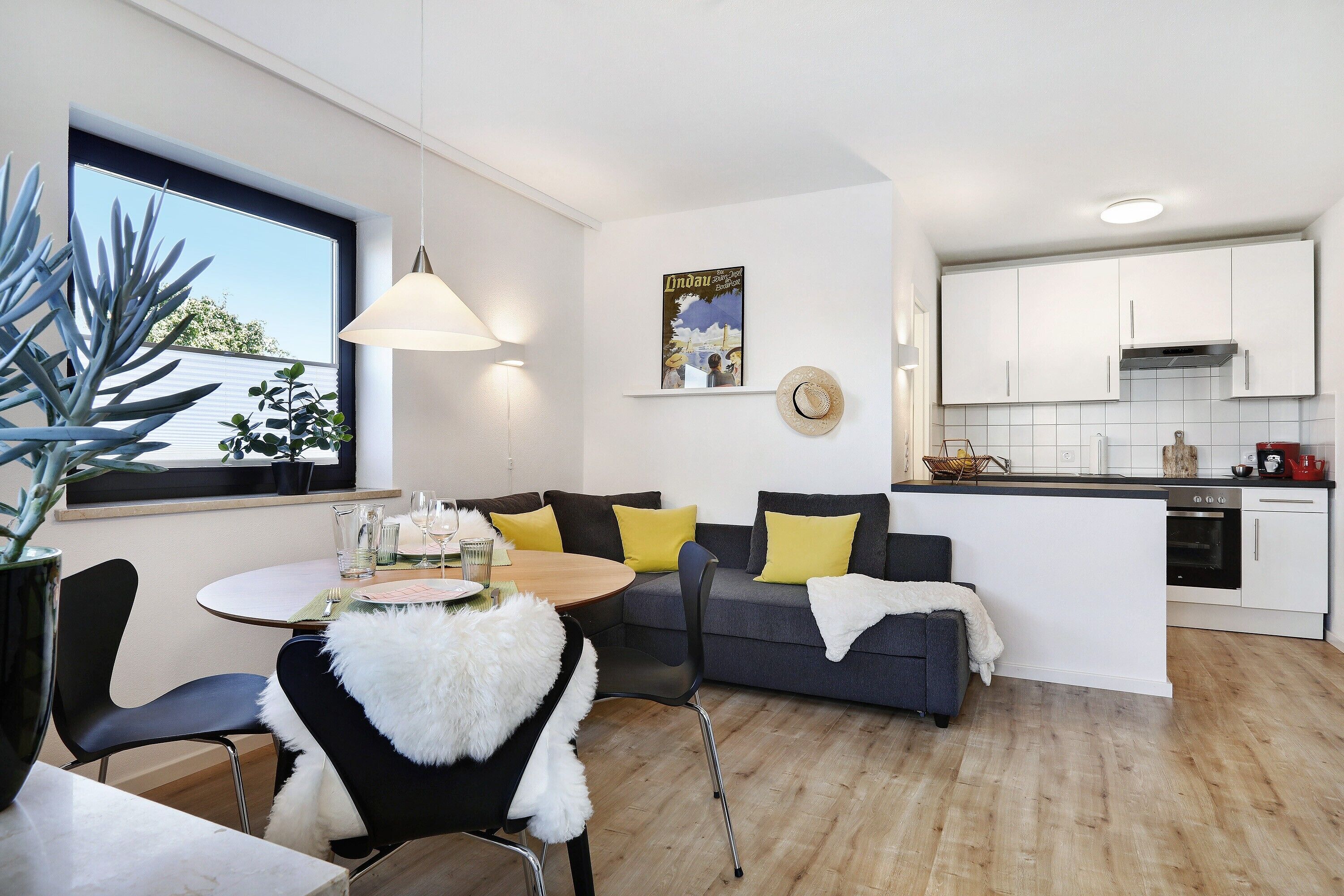 Ein modernes Wohnzimmer mit Esstisch, Sofa und Küchenbereich.