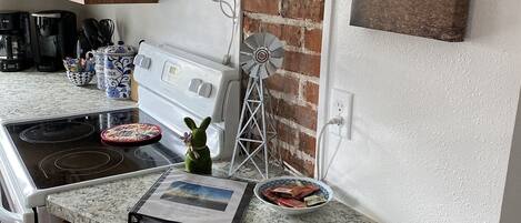 A kitchen with wooden cabinets, a microwave, a coffee maker, and a windmill decoration.