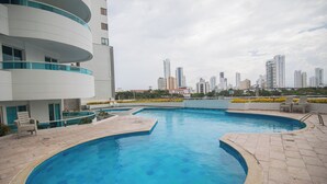 A swimming pool with a city skyline in the background. - Gorgeous views, 2 rooms, AC, Pool, beach, hot showers! (Cartagena)