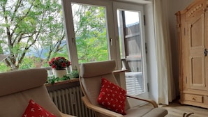 Una habitación acogedora con un ventanal grande, un armario de madera y un radiador.