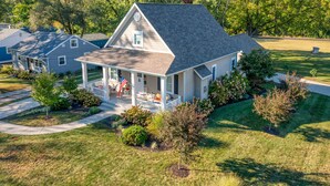 A single-story house with a covered porch, a small deck, and a well-maintained lawn.