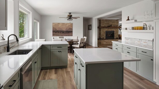 Een moderne keuken met een centraal eiland, een eetgedeelte met uitzicht op de bergen en een open haard.