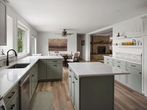 A modern kitchen with a central island, a dining area with a view of the mountains, and a fireplace. - Private Mountain View Home on 2 Acres in Bozeman (Bozeman)