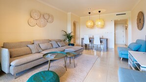 A modern living room with a sectional sofa, a coffee table, and a dining area with chairs and a table. - Lovely and comfortable apartment in Altea, on the Costa Blanca, Spain  with communal pool for 4 persons (Altea)