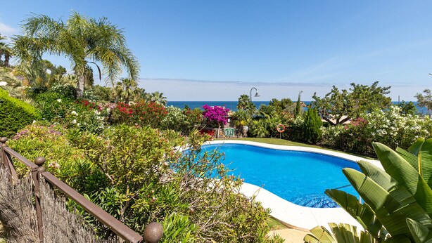 A swimming pool surrounded by lush greenery and a view of the ocean. - Lovely and comfortable apartment in Altea, on the Costa Blanca, Spain  with communal pool for 4 persons (Altea)