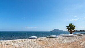 A pebbled beach with several boats and a palm tree. - Lovely and comfortable apartment in Altea, on the Costa Blanca, Spain  with communal pool for 4 persons (Altea)