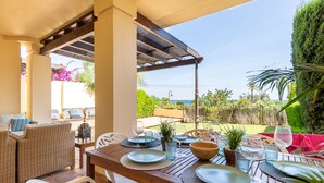 An outdoor dining area with wicker furniture, a wooden table, and a view of the sea. - Lovely and comfortable apartment in Altea, on the Costa Blanca, Spain  with communal pool for 4 persons (Altea)