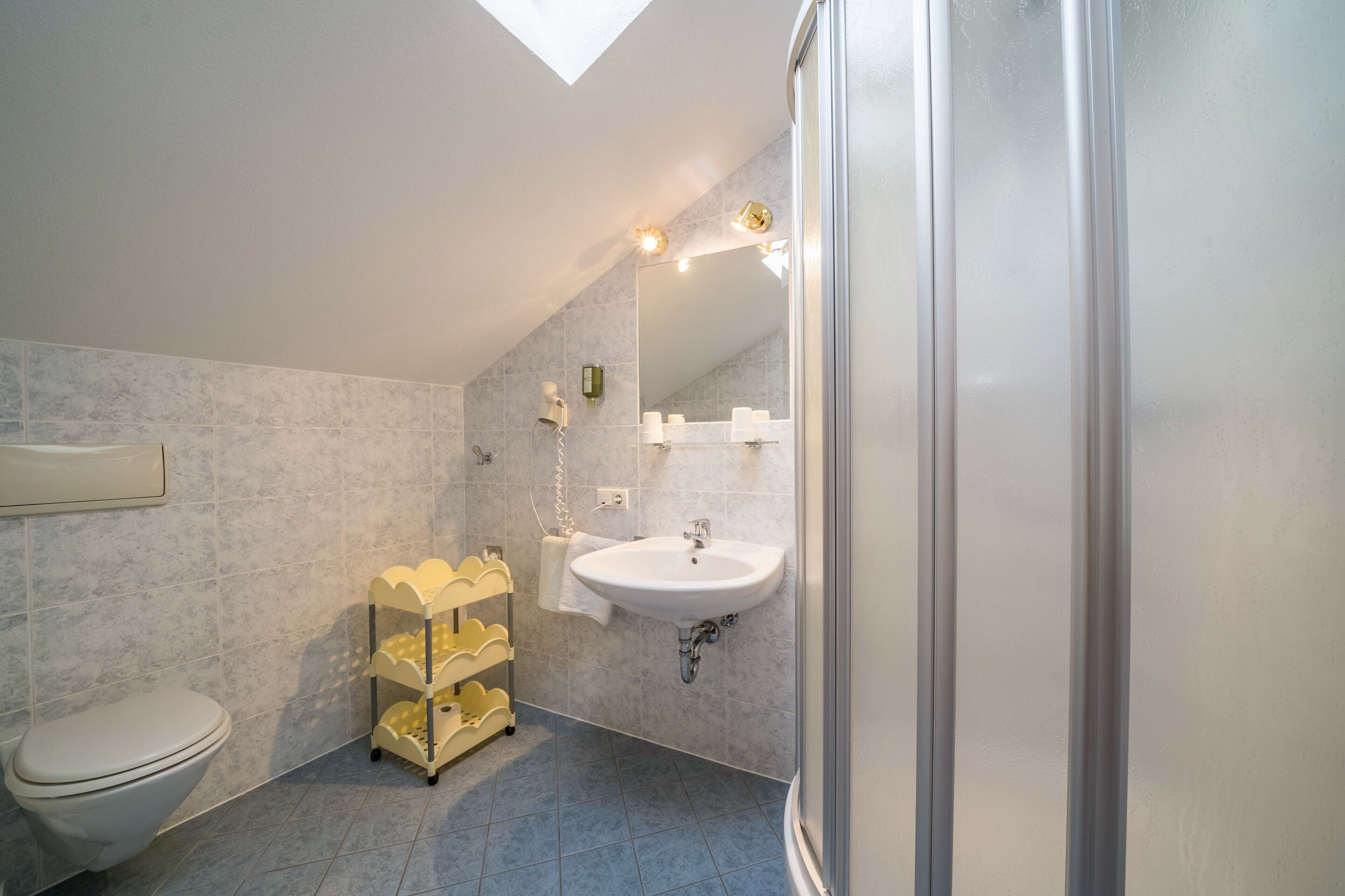 Une salle de bain avec des toilettes, un lavabo et une douche.