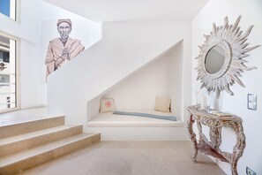 A staircase with a built-in bench, a decorative mirror, and a wall-mounted artwork.
