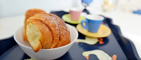 Una mesa con un bol de pan, una taza y un globo terráqueo.
