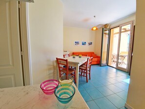 Ein Essbereich mit Tisch, Stühlen und bunten Schüsseln.