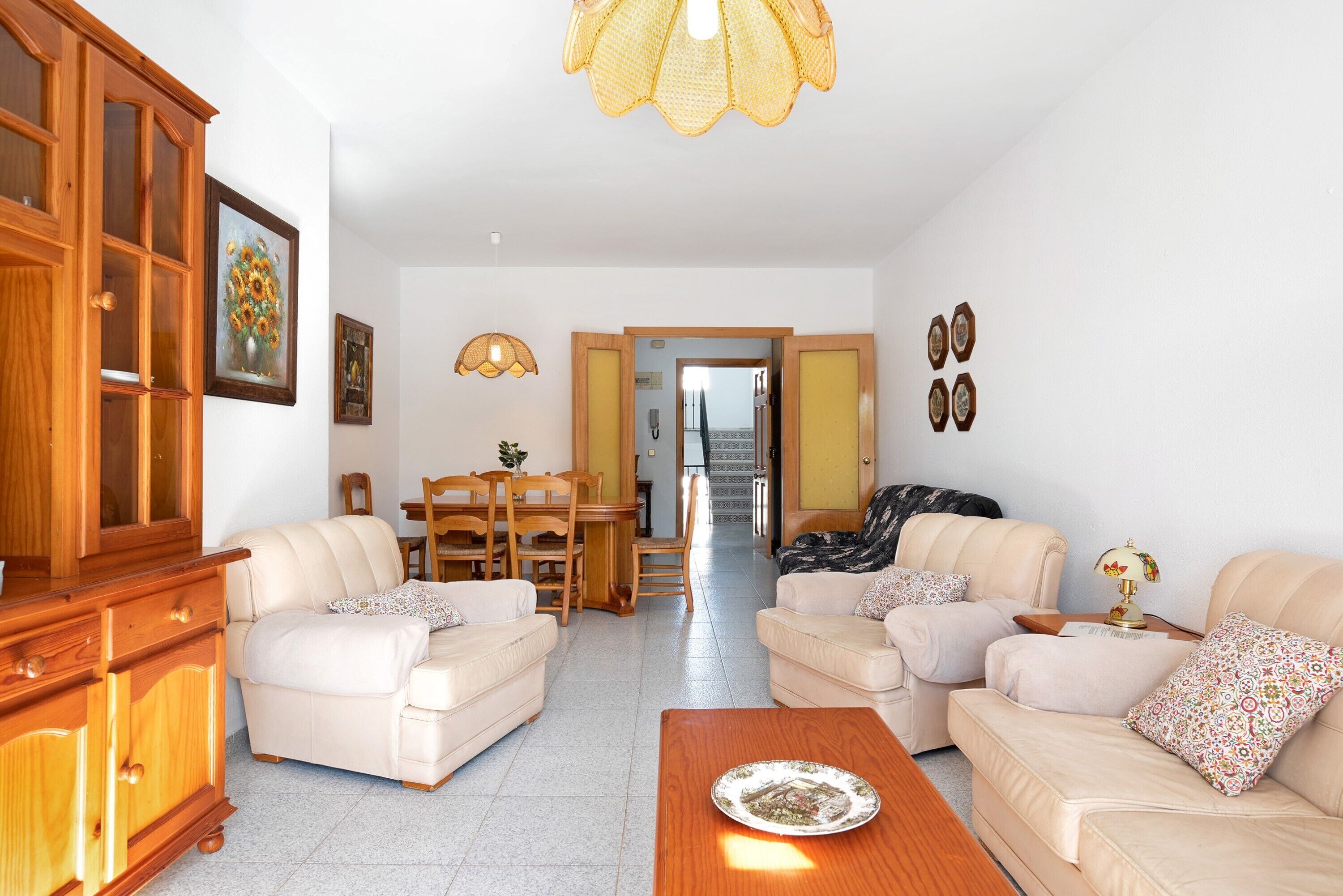 Ein Wohnzimmer mit zwei Sofas, einem Holzkasten und einem Essbereich mit Stühlen und einem Tisch.