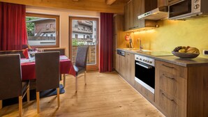 Une cuisine avec des meubles en bois, un four à micro-ondes et un coin repas comprenant une table et des chaises.