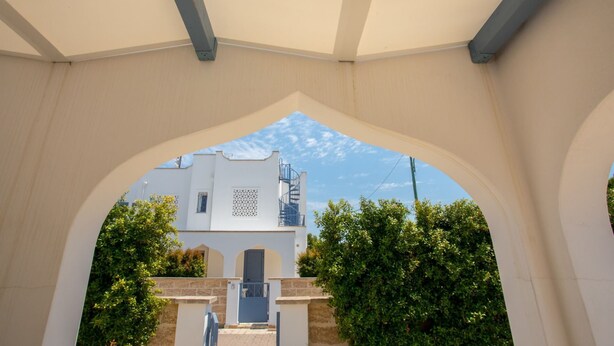 An architectural archway leading to a building with a spiral staircase and a door. - Villetta Clara, holiday house close to the beach (Nardo)